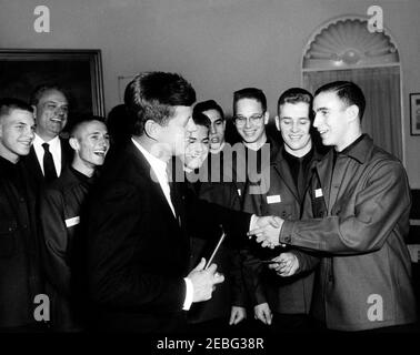 Visita dei rappresentanti di Boy Scouts of America (BSA), ORE 12:55. Il presidente John F. Kennedy incontra dodici Boy Scouts che rappresentano le dodici diverse regioni negli Stati Uniti, Oval Office, White House, Washington, D.C. Boy Scout Richard G. Pingree di Georgetown, Massachusetts, presenta al presidente Kennedy una tessera d'iscrizione onoraria. (L-R) tre rappresentanti non identificati; il presidente Kennedy; Richard Osher; Ronald Cowan; George Ashley; James Stivers; Richard Pingree. Foto Stock