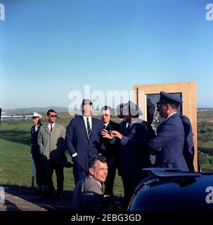 Viaggio in California: Base dell'aeronautica di Vandenberg, 16:08. Il presidente John F. Kennedy (indossando gli occhiali da sole) guarda il lancio del missile Atlas 134D alla base dell'aeronautica di Vandenberg, California. Da sinistra a destra: Uomo non identificato; agente di Servizio segreto della Casa Bianca, Bob Lilley; presidente Kennedy; direttore di Ricerca e sviluppo per il Dipartimento della Difesa, Dr. Harold Brown; comandante del comando aereo strategico, generale Thomas S. Power; Air Force Aide al presidente, Brigadier Generale Godfrey T. McHugh. Un fotografo non identificato sta in primo piano. Foto Stock