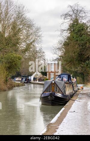 Braunston, Northamptonshire, Regno Unito - 11 febbraio 2021: Barche a chioccia ormeggiate su un canale ghiacciato Grand Union da un sentiero ghiacciato vicino alla marina di Braunston. Foto Stock