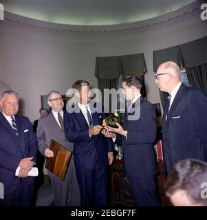 Visita del Boysu0027 Clubsu0027 u0022Boy dell'anno, u0022 Stephen Lutz, 10:57. Il presidente John F. Kennedy (al centro) possiede un modello in scala, racchiuso all'interno di una bottiglia, di PT Boat 109, presentato a lui dai Boysu0027 Clubs of Americau0027s (BCA) u0022Boy dello Yearu0022 Stephen Lutz di Newark, New Jersey. (L-R) Albert L. Cole, presidente della BCA; uomo non identificato (nel retro, parzialmente nascosto); John M. Gleason, direttore nazionale della BCA; il presidente Kennedy; Stephen Lutz; e Charles R. Messier, direttore esecutivo dei Boysu0027 Clubs di Newark, New Jersey. Ufficio ovale, Casa Bianca, Foto Stock