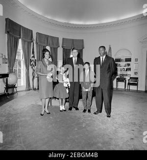 Visita di Myrlie Evers, vedova di Medgar Evers, e la famiglia. Il presidente John F. Kennedy (centro) visita con Myrlie Evers (all'estrema sinistra), vedova del leader dei diritti civili, Medgar Evers. Anche nella foto: Reena e Darrell Evers, figli di Medgar e Myrlie; Charles Evers (a destra), fratello di Medgar. Ufficio ovale, Casa Bianca, Washington, D.C. Foto Stock