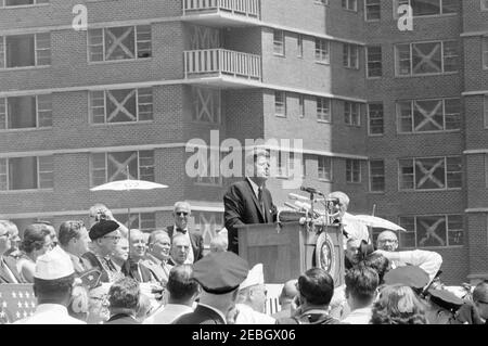 Viaggio a New York City: International Ladies Garment Workers Union (ILGWU) Housing Project, 13:00. Il presidente John F. Kennedy (al leggio) esprime le sue osservazioni alla dedicazione delle Penn Station South cooperative Houses, un progetto cooperativo di alloggi dell'Unione Internazionale di lavoro per l'abbigliamento Ladiesu2019 (ILGWU). Anche nella foto: Governatore di New York, Nelson Rockefeller; ex prima signora, Eleanor Roosevelt; Vice Presidente Esecutivo dell'ILGWU, Louis Stulberg; Vice Presidente dell'ILGWU, Luigi Antonini; Presidente di United Hatters, Cap, e Millinery Workers International Union, Alex Ros Foto Stock