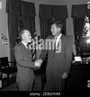 Visita dei membri del Comitato per l'Educazione politica (COPE) e dell'AFL-CIO (Federazione americana del lavoro e Congresso delle organizzazioni industriali), alle 17:45. Il presidente John F. Kennedy stringe le mani con un uomo non identificato (a sinistra) durante una visita con i delegati a una conferenza sulla registrazione degli elettori sponsorizzata dalla Federazione americana del lavoro e del Congresso delle organizzazioni industriali (AFL-CIO) Committee on Political Education (COPE). Ufficio ovale, Casa Bianca, Washington, D.C. Foto Stock