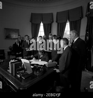 205 Legge pubblica 87-447, Legge sulla Televisione educativa, 12:00 PM. Il presidente John F. Kennedy (seduto) firma la legge sulla televisione educativa. In piedi (L-R): Due uomini non identificati; senatore Clifford P. Case (New Jersey); non identificato (sul retro); congressista John E. Moss (California); congressista Oren Harris (Arkansas); non identificato; senatore Norris Cotton (New Hampshire); senatore Warren G. Magnuson di Washington (testa girata); senatore John O. Pastore (Rhode, Island); avvocato Mark H. Membro del Congresso William L. Springer (Illinois). Presente anche: Presidente dell'Associazione Nazionale Foto Stock