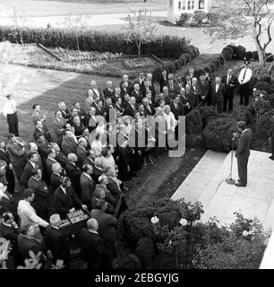 Visita dei membri del Comitato per l'Educazione politica (COPE) e dell'AFL-CIO (Federazione americana del lavoro e Congresso delle organizzazioni industriali), alle 17:45. Il presidente John F. Kennedy (a destra, ai microfoni) si rivolge ai delegati di una conferenza sulla registrazione degli elettori sponsorizzata dalla Federazione americana del lavoro e del Congresso delle organizzazioni industriali (AFL-CIO) Committee on Political Education (COPE). Anche nella foto: Ufficiale della White House Communications Agency (WHCA), Oscar N. Smith; e capo della White House Police, maggiore Ralph C. u0022Smokeyu0022 Stover. Rose Garden, Casa Bianca, Washington, D.C. Foto Stock