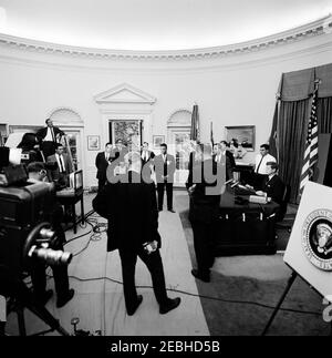 Radio u0026 Indirizzo televisivo alla nazione sul Trattato di divieto nucleare e la legge di riduzione fiscale, 19:00 PM. Il presidente John F. Kennedy (estrema destra) si prepara a trasmettere un messaggio televisivo sul Trattato per la messa al bando degli esperimenti nucleari e sulla legislazione volta a ridurre le tasse federali. Anche nella foto: White House Press Secretary, Pierre Salinger (dietro il presidente Kennedy); White House media network electrician, Cleve Ryan (in piedi sulla scala a sinistra); e membri non identificati dei media. Ufficio ovale, Casa Bianca, Washington, D.C. Foto Stock