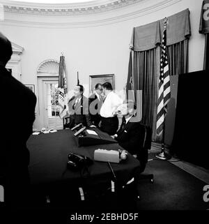 Radio u0026 Indirizzo televisivo alla nazione sul Trattato di divieto nucleare e la legge di riduzione fiscale, 19:00 PM. Il presidente John F. Kennedy (estrema destra) si prepara a trasmettere un messaggio televisivo sul Trattato per la messa al bando degli esperimenti nucleari e sulla legislazione volta a ridurre le tasse federali. Il segretario della Casa Bianca Pierre Salinger (con camicia bianca) e due uomini non identificati stanno accanto. Ufficio ovale, Casa Bianca, Washington, D.C. Foto Stock