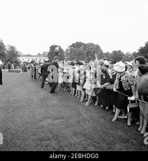 Visita dei partecipanti alla Conferenza della Campagna 1962 per le Donne democratiche, alle 9:35. Il presidente John F. Kennedy saluta i partecipanti alla Conferenza sulla Campagna per le Donne democratiche del 1962; First Lady Jacqueline Kennedy e Vice Presidente Lyndon B. Johnson (per lo più nascosto) accolgono i visitatori all'estrema sinistra. Anche nella foto: Corrispondente di Washington per la Guy Gannet Publishing Company del Maine, May Craig; primo segretario stampa Ladyu0027s, Pamela Turnure; Assistente speciale al presidente, Arthur M. Schlesinger, Jr.; Vice-presidente del Comitato Nazionale democratico (DNC), Margaret B. Price. Prato Sud, Foto Stock