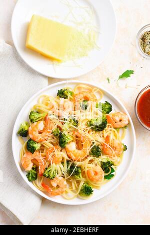 Gamberi e broccoli su piastra su fondo di pietra leggera. Piatto gustoso per cena. Vista dall'alto, piatto Foto Stock