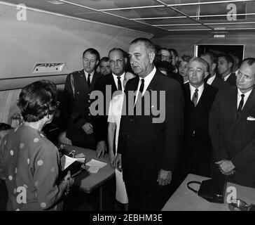 Viaggio in Texas: Cerimonia di giuramento a bordo di Air Force One, Lyndon B. Johnson (LBJ) come presidente. I funzionari si riuniscono all'interno dell'Air Force One per il giuramento del presidente Lyndon B. Johnson all'Love Field di Dallas, Texas, in seguito all'assassinio del presidente John F. Kennedy. Da sinistra a destra: Assistente del segretario stampa, Malcolm Kilduff (principalmente nascosto in basso a sinistra); giudice Sarah T. Hughes; militare Aide al presidente Kennedy, generale Chester V. Clifton; collegamento dei media, Jack Valenti; capo della polizia di Dallas, Jesse Curry; First Lady Bird Johnson; presidente Johnson; presidente Kennedyu2019s personale sec Foto Stock