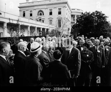 Visita dei delegati alla sessione 1963, Consiglio di Gestione del Comitato consultivo per gli Studi postali, Unione postale universale, 9:35. Il Presidente John F. Kennedy (centro destra) visita con delegati internazionali all'Unionu0027s 1963 sessione del Consiglio di Gestione del Comitato consultivo per gli Studi postali. Rose Garden, Casa Bianca, Washington, D.C. Foto Stock