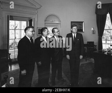 Incontro con il governatore Grant Sawyer del Nevada e i senatori Alan Bible e Howard W. Cannon (Nevada), 16:35. Il presidente John F. Kennedy si trova in piedi con funzionari del Nevada. Da sinistra a destra: Il governatore Grant Sawyer, il senatore Howard W. Cannon, la Bibbia del senatore Alan e il presidente Kennedy. Ufficio ovale, Casa Bianca, Washington, D.C. Foto Stock