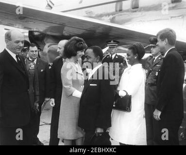 Cerimonia di arrivo per Fu00e9lix Houphouu00ebt-Boigny, Presidente della Costa d'Avorio, ore 12. Il Presidente John F. Kennedy e la First Lady Jacqueline Kennedy salutano il Presidente della Costa d'Avorio, Fu00e9lix Houphouu00ebt-Boigny, e la First Lady della Costa d'Avorio, Marie-Thu00e9ru00e8se Houphou00ebt-Boigny, al loro arrivo all'Aeroporto Nazionale di Washington. Da sinistra a destra: Segretario di Stato degli Stati Uniti, Dean Rusk; Air Force Aide al Presidente Kennedy, Brigadier Generale Godfrey T. McHugh; interprete del Dipartimento di Stato degli Stati Uniti, Edmund S. Glenn; capo del protocollo degli Stati Uniti, Angier Biddle Duke; Mrs. Kennedy (presenti Foto Stock