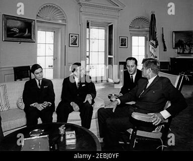 Incontro con Miguel Aleman, ex presidente del Messico, ore 10. Il presidente John F. Kennedy (in sedia a dondolo) incontra l'ex presidente del Messico, Miguel Alemu00e1n. Da sinistra a destra: Non identificato; Alemu00e1n; interprete del Dipartimento di Stato, Donald Barnes; presidente Kennedy. Ufficio ovale, Casa Bianca, Washington, D.C. Foto Stock