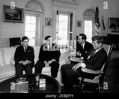 Incontro con Miguel Aleman, ex presidente del Messico, ore 10. Il presidente John F. Kennedy (in sedia a dondolo) incontra l'ex presidente del Messico, Miguel Alemu00e1n. Da sinistra a destra: Non identificato; Alemu00e1n; interprete del Dipartimento di Stato, Donald Barnes; presidente Kennedy. Ufficio ovale, Casa Bianca, Washington, D.C. Foto Stock