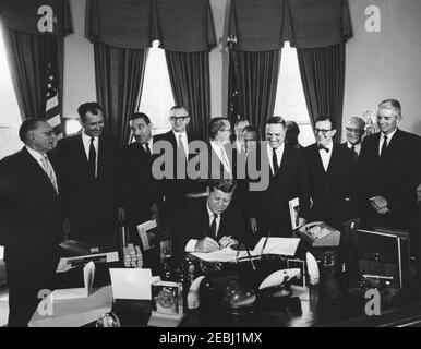 476 legge pubblica 87-657, Point Reyes National Seashore, 9:55. Il presidente John F. Kennedy (seduto al banco) firma S. 476, un disegno di legge per stabilire il Point Reyes National Seashore in California. In piedi (L-R): Rappresentante Wayne N. Aspinall (Colorado); rappresentante J. T. Rutherford (Texas); Segretario dell'interno Stewart Udall; rappresentante John P. Saylor (Pennsylvania); senatore Alan Bible (Nevada); senatore Hubert H. Humphrey del Minnesota (in parte nascosto); senatore Clair Encole (California); rappresentante Cunlem identificato (California); Represin (California) Foto Stock