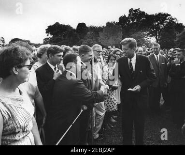 Visita dei tirocinanti del corpo della Pace, 16:25. Il presidente John F. Kennedy (centro a destra) saluta un gruppo di tirocinanti del corpo della Pace; l'agente del servizio segreto della Casa Bianca, Arthur L. u201cArtu201d Godfrey, si trova a destra. South Lawn, Casa Bianca, Washington, D.C. Foto Stock