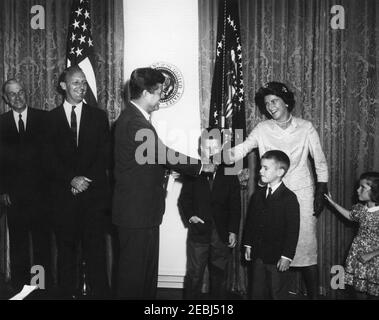 Giuramento in cerimonia, William Battle, Ambasciatore degli Stati Uniti in Australia, 17:14. Il presidente John F. Kennedy scuote le mani con Barry Webb Battle, moglie del neo-nominato ambasciatore degli Stati Uniti in Australia, William C. Battle, durante la cerimonia di giuramento del sig. Battleu0027s. Da sinistra a destra: Ex Governatore della Virginia, John S. Battle; Battaglia dell'Ambasciatore; Presidente Kennedy; Battaglia di W. Cullen, Jr.; Battaglia di Robert W.; Battaglia di Janie. Sala armadio, Casa Bianca, Washington, D.C. Foto Stock