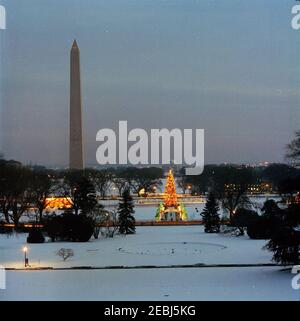 Albero di Natale di Nationu2019s, vista al tramonto dalla Casa Bianca. Vista dalla Casa Bianca dell'albero di Natale Nazionale al tramonto, illuminato da luci multicolore, sull'Ellipse innevata al Presidentu0027s Park, Washington, D.C. il Washington Monument e il Jefferson Memorial sono visibili sullo sfondo. Foto Stock