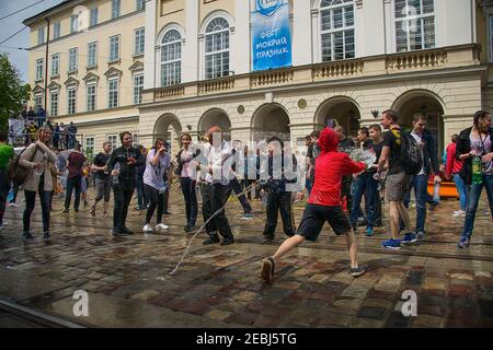 Lviv, Ucraina - 2 maggio 2016: Festa che versa l'acqua il Lunedi dopo Pasqua presso il municipio. Ragazzo felice che versa acqua sulla ragazza. Foto Stock