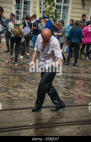 Lviv, Ucraina - 2 maggio 2016: Festa che versa l'acqua il Lunedi dopo Pasqua presso il municipio. Uomini calvi che ballano tra un popolo Foto Stock