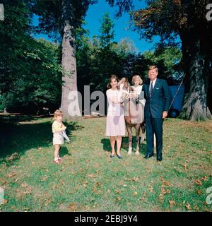 Presidente Kennedy, First Lady Jacqueline Kennedy (JBK), Caroline Kennedy (CBK) u0026 John F. Kennedy, Jr. (JFK, Jr.), con pony u201cLeprechaunu201d, dono del Presidente d'Irlanda u00c9amon de Valera. Il presidente John F. Kennedy, First Lady Jacqueline Kennedy, e i loro figli, Caroline Kennedy e John F. Kennedy, Jr., stanno con un pony Connemara, Leprechaun, dato in dono dal presidente d'Irlanda, u00c9amon de Valera. South Lawn, Casa Bianca, Washington, D.C. Foto Stock