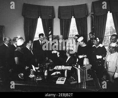 2399 Legge pubblica 87-633, designazione della casa di Frederick Douglass come parte del sistema del Parco nella capitale Nazionale, 9:45 AM. Il presidente John F. Kennedy consegna una penna al presidente nazionale dell'Associazione Nazionale dei Club colorati delle donne (NACWC), Dr. Rosa Gragg, dopo la firma di una legge che designa la casa di Frederick Douglassu2019 come parte del sistema del Parco Nazionale nella capitale Nazionale. In piedi (L-R): Presidente Emerito della Howard University, Mordechai W. Johnson; Vice Segretario dell'interno per la gestione delle terre pubbliche, John A. Carver (volto oscurato Foto Stock
