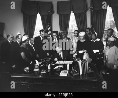 2399 Legge pubblica 87-633, designazione della casa di Frederick Douglass come parte del sistema del Parco nella capitale Nazionale, 9:45 AM. Il presidente John F. Kennedy firma una legge che designa la casa di Frederick Douglassu2019 come parte del sistema del parco nazionale nella capitale nazionale. Standing (L-R): Presidente Emerito della Howard University, Mordechai W. Johnson; Vice Segretario dell'interno per la gestione delle terre pubbliche, John A. Carver (volto oscurato); Presidente del Consiglio di amministrazione della D.C. dell'Associazione Nazionale dei Club Womenu2019s colorati (NACWC), Georgia Anderson; repressen Foto Stock