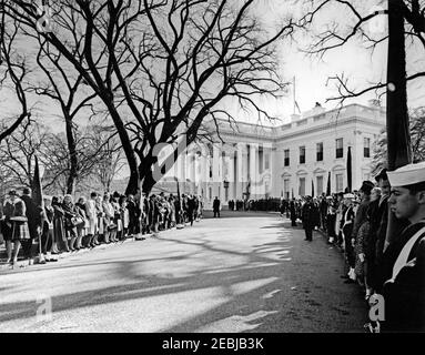 Funerale di Stato del Presidente Kennedy: Processione alla Cattedrale di San Matthewu2019s. Lutto e membri della linea di guardia di colore il viale Nord prato della Casa Bianca per la processione funebre del presidente John F. Kennedy alla Cattedrale di San Matteo Apostolo. Washington, D.C. Foto Stock