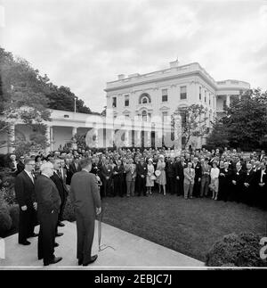 Visita dei rappresentanti dei Cutter di carne amalgamati e dei macellai del Nord America, ore 10:00. Il presidente John F. Kennedy (in carica ai microfoni) trasmette osservazioni ai rappresentanti dei macellai e dei macellai amalgamati del Nord America (AMC) nel Rose Garden della Casa Bianca, Washington, D.C.; Patrick Emmet Gorman, Segretario-Tesoriere Internazionale dell'AMC (con la mano destra in tasca), si trova sul patio, secondo da sinistra. [Nota: La linea orizzontale nella parte inferiore dell'immagine è da originale a negativo.] Foto Stock