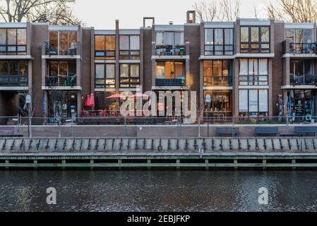 Lake Anne, Reston, VA, USA -- 1 marzo 2020. Una foto serale di negozi e appartamenti presi lungo il Lago di Anna, illuminato per l'avvicinarsi del tramonto. Foto Stock