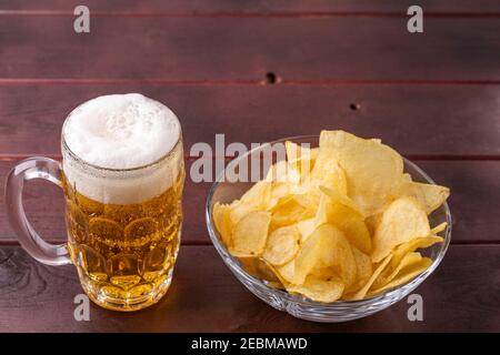 Vista ravvicinata della birra nella tazza di vetro e della tazza di patatine. Foto Stock