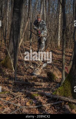 Hunter tiene il suo arco e freccia ricorsi fatti su misura mentre si avvicina alla sua uccisione nel Wisconsin settentrionale. Foto Stock