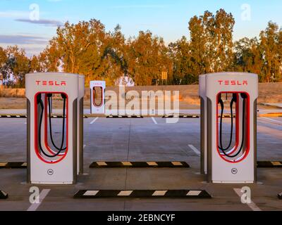 Firebaugh, USA - 21 gennaio 2021: File di super-caricabatterie elettrici Tesla vuoti dalla California Highway 5 Foto Stock