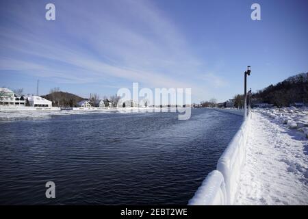 Grand Haven, Michigan, febbraio 2021, ringhiere e lampioni ricoperti di ghiaccio, lungo il sentiero innevato del molo, acqua invernale Foto Stock