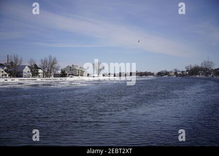 Grand Haven, Michigan, febbraio 2021, ringhiere e lampioni ricoperti di ghiaccio, lungo il sentiero innevato del molo, acqua invernale Foto Stock