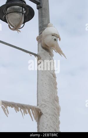 Febbraio 12 2021 Port Stanley, Ontario, Canada. Lampione e telecamera di sicurezza coperti di ghiaccio alle porte del molo. Luke Durda/Alamy Foto Stock