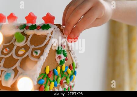 Torta della casa di pan di zenzero decorante a mano Foto Stock