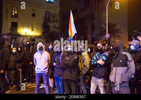 Barcellona, Spagna. 12 Feb 2021. Durante la dimostrazione antifascista si vedono dimostranti che indossano maschere facciali. I gruppi antifascisti di Barcellona hanno manifestato contro un atto celebrativo del partito di estrema destra spagnolo, Vox, che ha convocato i sostenitori per la chiusura della campagna politica per le elezioni per la generalità della Catalogna il 14 febbraio. Credit: SOPA Images Limited/Alamy Live News Foto Stock