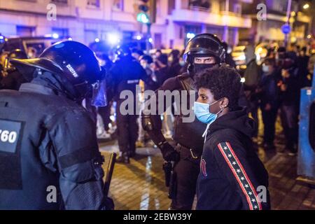 Barcellona, Spagna. 12 Feb 2021. I poliziotti cercano un dimostratore antifascista durante la manifestazione antifascista. I gruppi antifascisti di Barcellona hanno manifestato contro un atto celebrativo del partito di estrema destra spagnolo, Vox, che ha convocato i sostenitori per la chiusura della campagna politica per le elezioni per la generalità della Catalogna il 14 febbraio. Credit: SOPA Images Limited/Alamy Live News Foto Stock