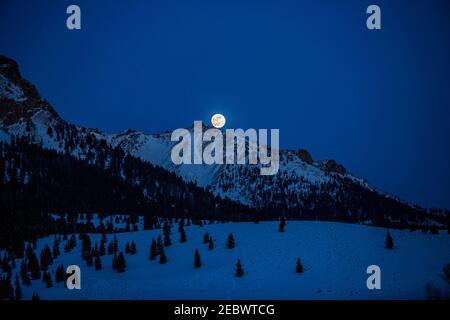 USA, Idaho, Sun Valley, Luna piena che si erge sulle Boulder Mountains nella notte invernale Foto Stock
