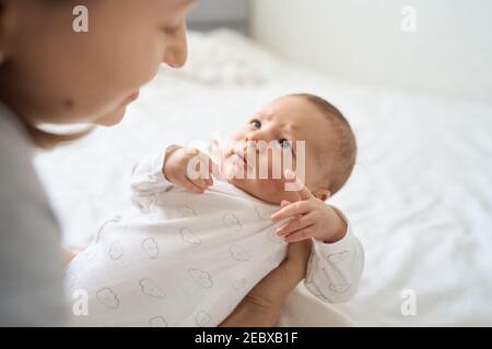 Bel bambino sulle mani della madre in guardaroba della stanza. Maternità. Infanzia. Foto Stock