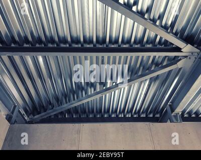 Strutture metalliche di supporto per soffitti e lamiere profilate in acciaio inox. Travi e travi a soffitto Foto Stock