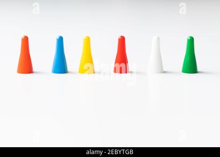 I chip di gioco multicolore e i cubetti di dadi sono raggruppati insieme su uno sfondo bianco: Il concetto di giochi da tavolo, intrattenimento, sfondo, giochi a. Foto Stock