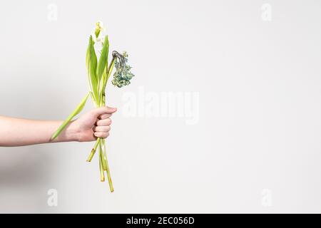 la mano dell'uomo tiene fuori un bouquet di fiori selvaggi. concetto di separazione. disposizione con posto per il testo Foto Stock