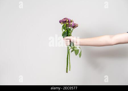 la mano dell'uomo tiene fuori un bouquet di fiori selvaggi. concetto di separazione. disposizione con posto per il testo Foto Stock