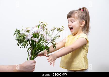 cute baby girl riceve un bel bouquet di fiori bianchi Foto Stock