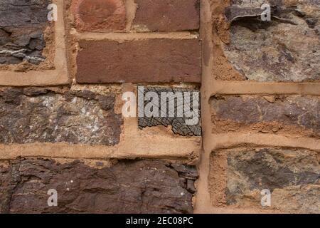 dettaglio di arancione sollevato puntando utilizzato tra la costruzione di pietra di costruzione e taglio di travi di legno Foto Stock