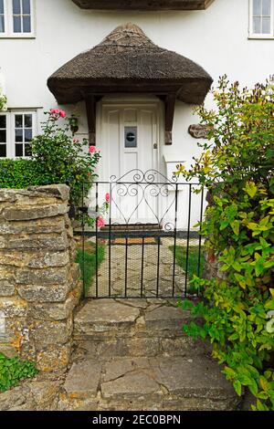 Porta di fronte a un cottage con tetto di paglia a Lulworth Cove, Dorset Foto Stock