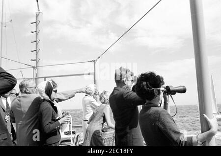 Il presidente Kennedy si accuda alla prima gara di Coppa Americau0027s. Il presidente John F. Kennedy (guardando attraverso il binocolo) e First Lady Jacqueline Kennedy (a sinistra) guardano la prima gara della Coppa Americau0027s 1962 a bordo della USS Joseph P. Kennedy, Jr. Anche nella foto: Hugh D. Auchincloss; Barbara Mechem Smith, moglie del senatore Benjamin A. Smith II (Massachusetts). Newport, Rhode Island. Foto Stock